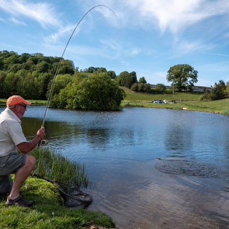 Mike netting a Wal Goch rainbowtrout Trout using a Black skinny jungle cock flash back diawl bach
